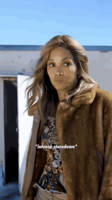 a woman wearing a fur coat and a t-shirt says intense staredown