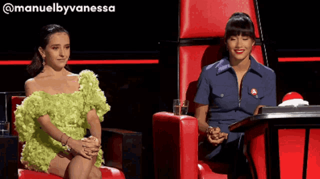 a woman in a green dress sits next to another woman in a blue uniform