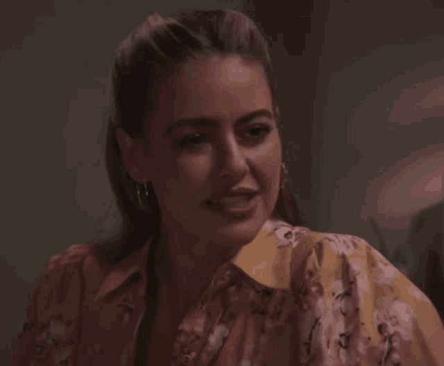 a woman wearing a floral shirt is smiling