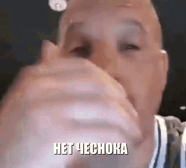 a close up of a man covering his mouth with his hand and the words het chechora written above him