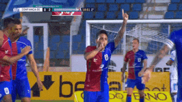 a group of soccer players are celebrating a goal in front of a sign that says ' be ' on it