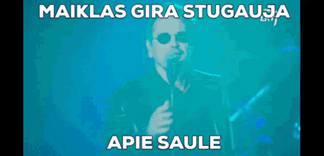 a man singing into a microphone with the words maiklas gira stugausa apie saule