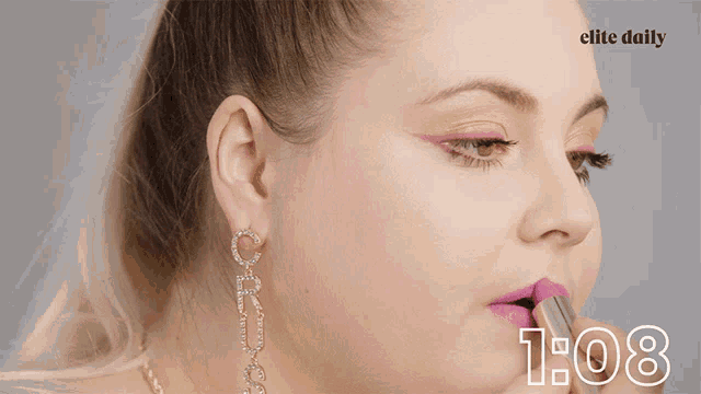 a close up of a woman applying lipstick with the time of 1:08