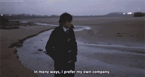 a man standing on a beach with the words in many ways i prefer my own company written below him