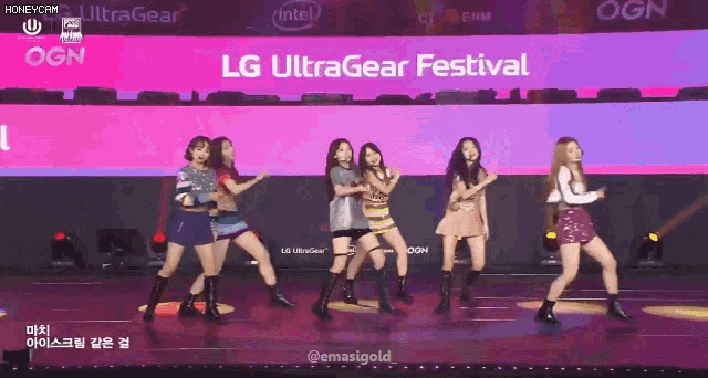 a group of girls are dancing on stage in front of an lg ultragear festival sign