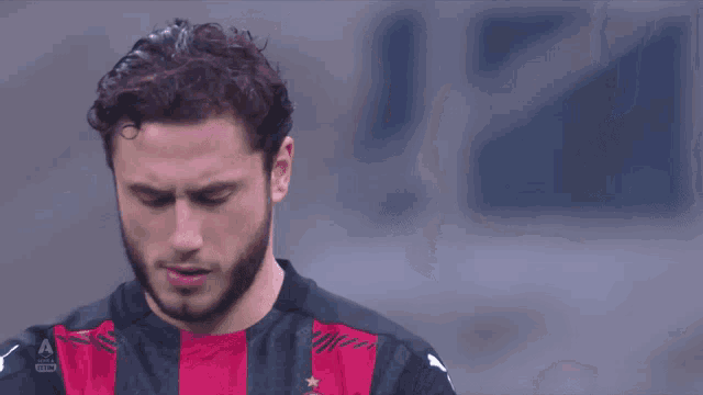 a man with a beard is wearing a black and red shirt with a puma logo
