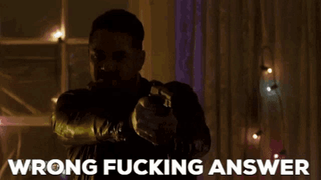 a man holding a gun with the words wrong fucking answer behind him .