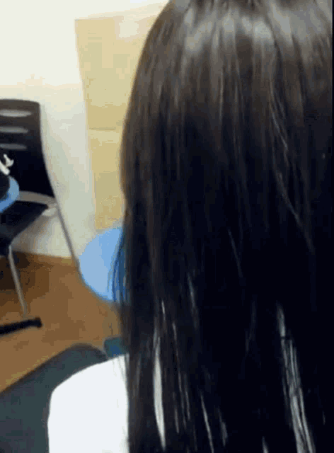 a close up of a woman 's head with long black hair