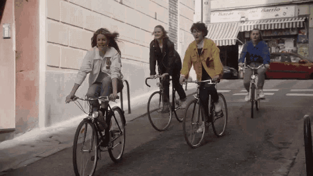 a group of people are riding bicycles down a street with a sign that says bazar on it