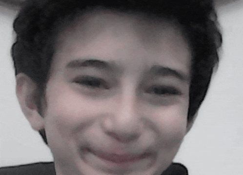 a close up of a young boy 's face with a smile
