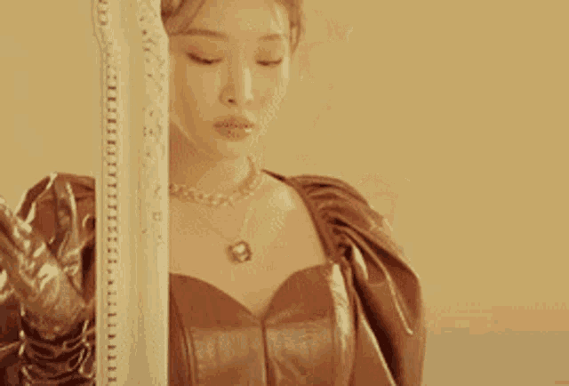 a woman in a brown dress and gloves holds a ruler
