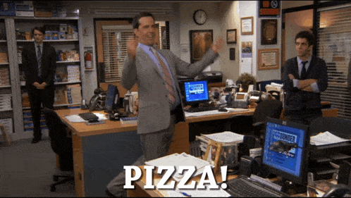 a man in a suit stands in front of a desk that says pizza on it