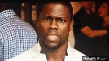 a man with a beard is making a funny face in front of a crowd of people .
