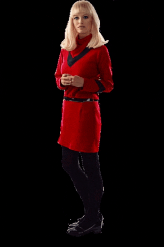 a blonde woman in a red dress and black tights is standing in front of a black background
