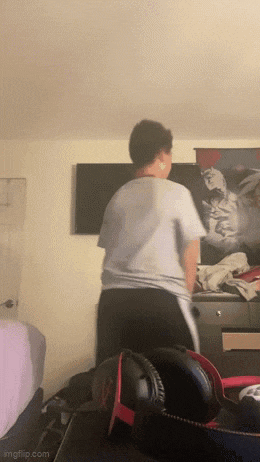 a person is standing in front of a television in a bedroom