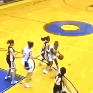 a blurry picture of people playing basketball on a yellow and blue court