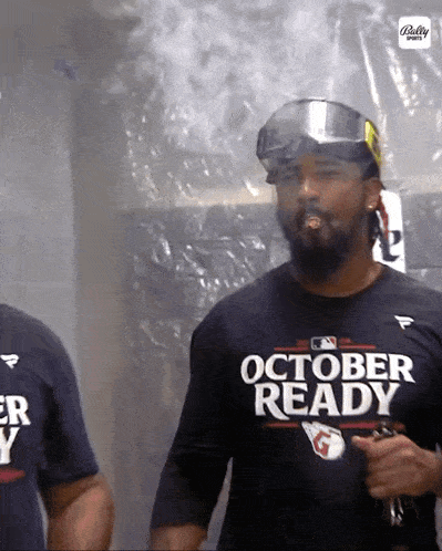 a man wearing a black shirt that says october ready smoking a cigarette