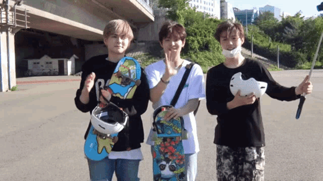 three young men are standing next to each other holding skateboards