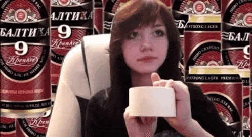 a woman is holding a piece of tape in front of a wall of baltika 9 cans
