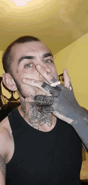 a man smoking a cigarette with a tattoo on his arm
