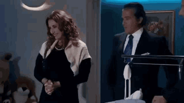 a man and a woman are standing next to each other in a room and talking .