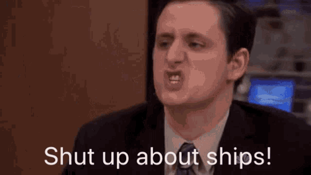 a man in a suit and tie is making a funny face and saying shut up about ships .
