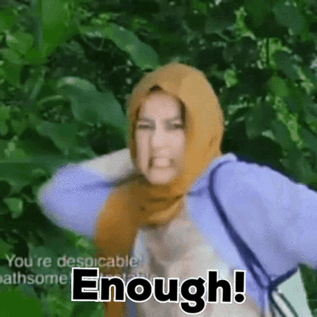 a woman wearing a hijab is making a funny face and the words enough are behind her .