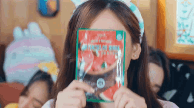 a woman holding a bag of watermelon slices in front of her face