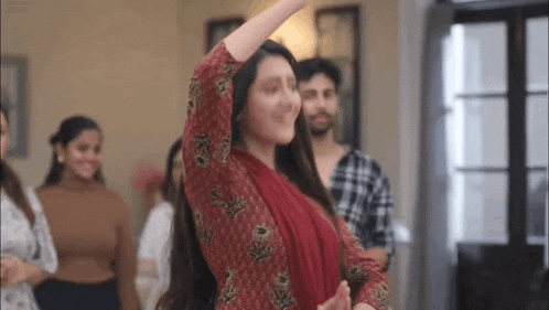 a woman is dancing in front of a group of people in a room .