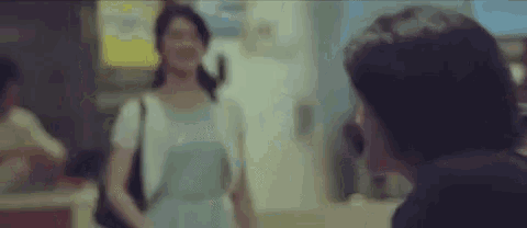 a blurry picture of a man and a woman standing next to each other in a room .