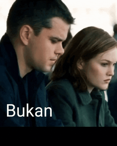 a man and a woman are sitting next to each other and the word bukan is on the bottom right