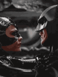 a man in a batman costume and a woman in a catwoman costume look at each other