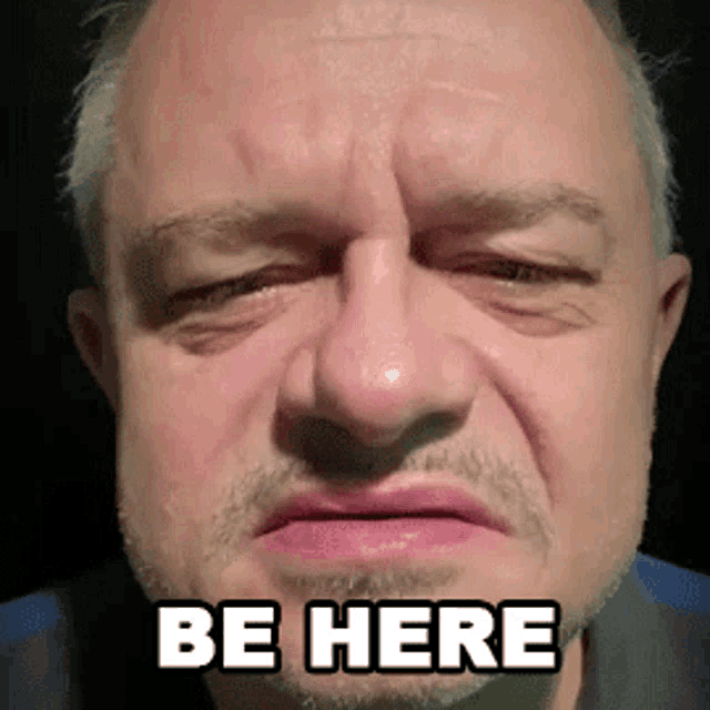 a close up of a man 's face with the words be here written on his face