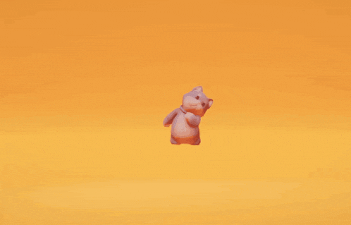 a stuffed animal is jumping in the air against an orange background