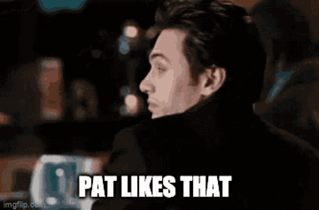 a man is sitting at a table with the words pat likes that written on it .