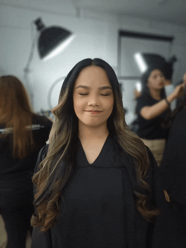 a woman with her eyes closed is wearing a black shirt with the letter a on it