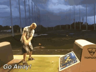a man is swinging a golf club on a driving range and the words go away are visible