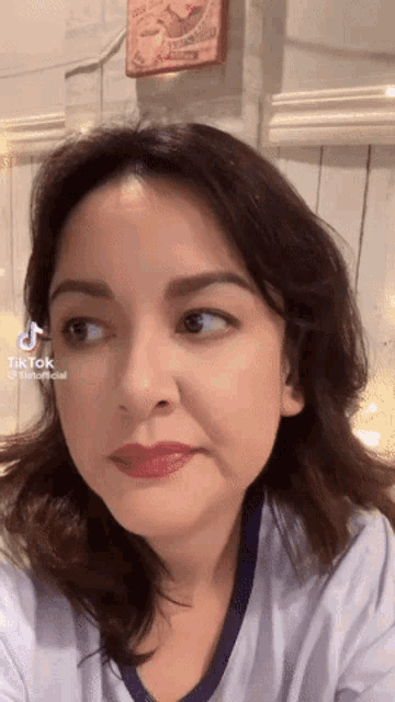 a close up of a woman 's face with a tik tok sticker on her face
