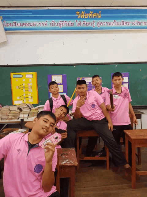 a group of boys in pink shirts are posing for a photo