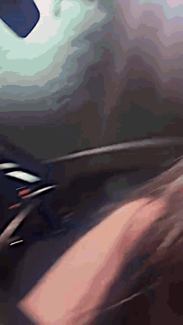 a blurry picture of a person 's torso with a phone behind them