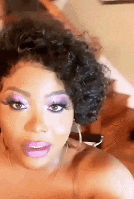 a close up of a woman 's face with purple eyeshadow