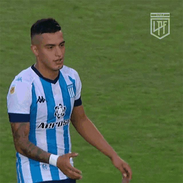 a soccer player wearing a blue and white aeros jersey is talking to a referee