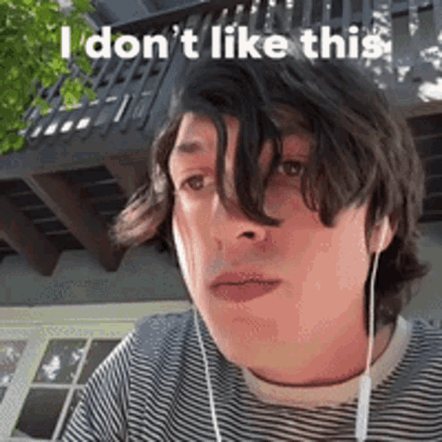 a man wearing ear buds and a striped shirt says i do n't like this