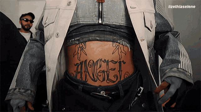 a person with a tattoo on their stomach that says " angel "