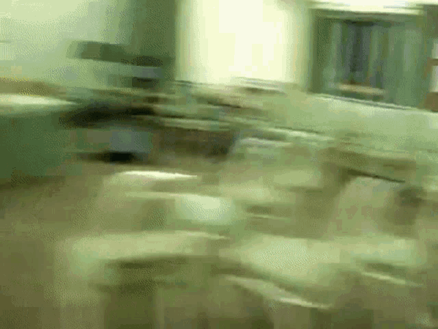 a blurry picture of a classroom with a lot of desks