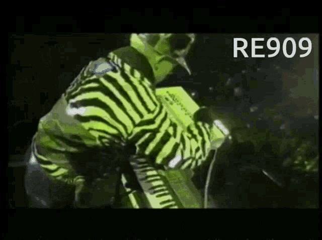 a man wearing a zebra print jacket is playing a keyboard