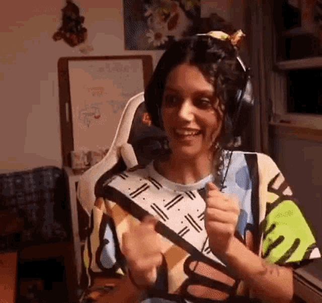 a woman wearing headphones is sitting in a chair in a room .