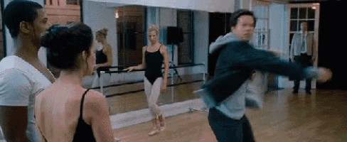 a group of people are standing in a dance studio .