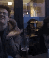 a man sitting at a table with a glass of beer on it