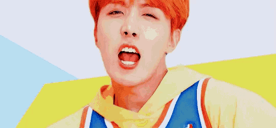 a young man with red hair is making a funny face .